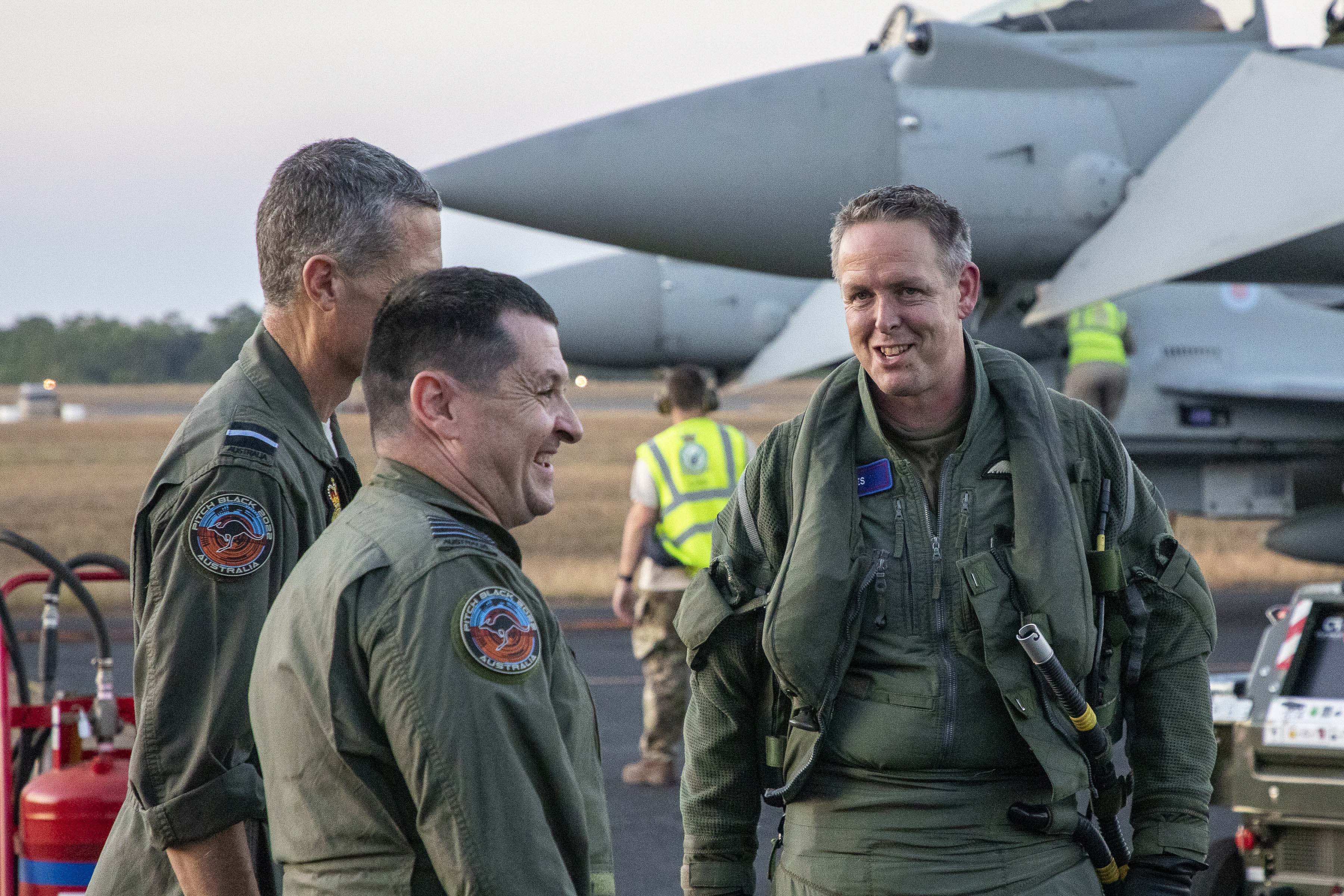 Image shows RAF aviators on the airfield with Typhoon aircraft in the background.